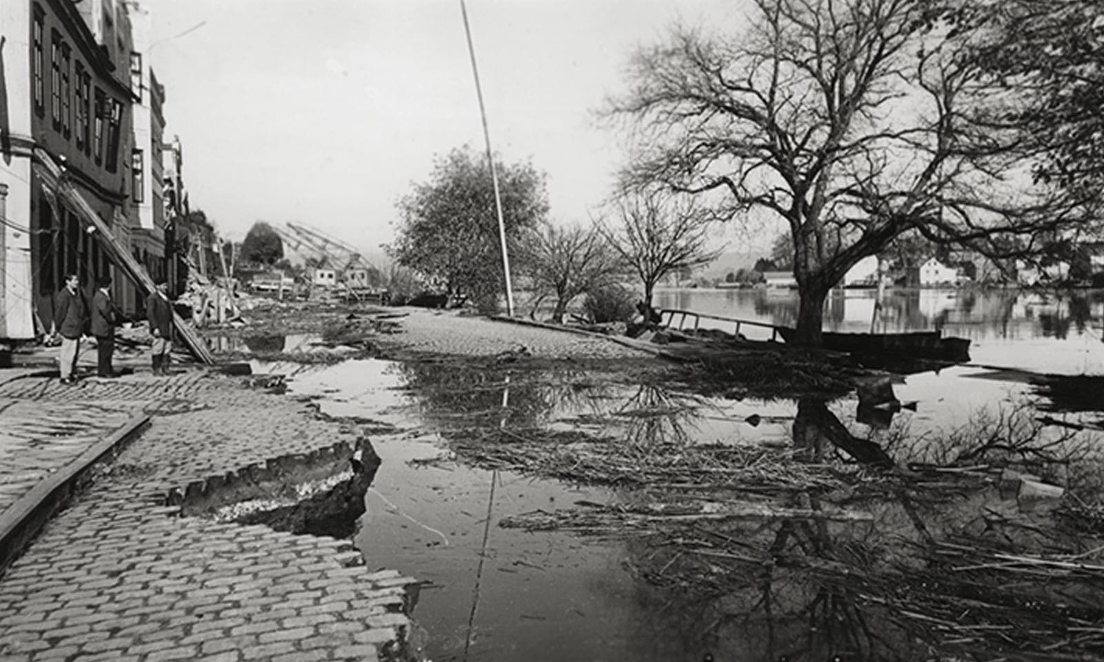 Calle inundada y pavimento agrietado en Valdivia tras el terremoto de 1960, el mismo episodio que inundó los terrenos de la empresa familiar